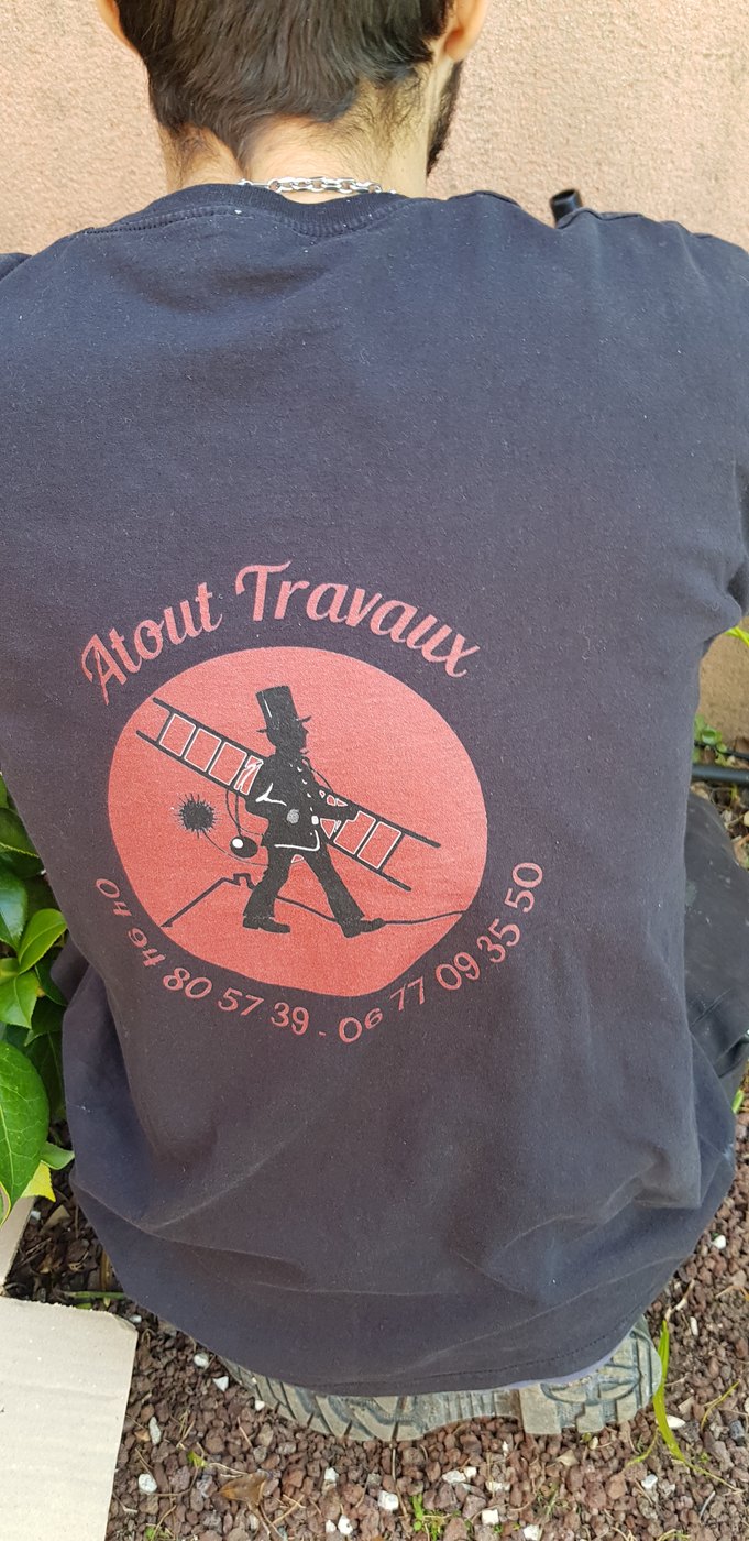 Logo Atout Travaux sur une tenue de travail