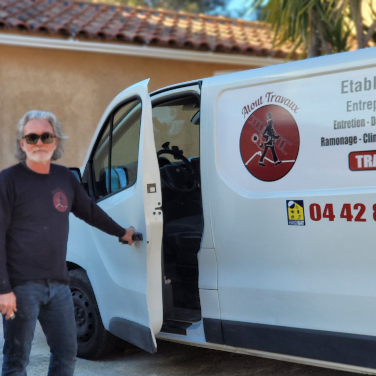 Artisan Atout Travaux devant son véhicule d'intervention