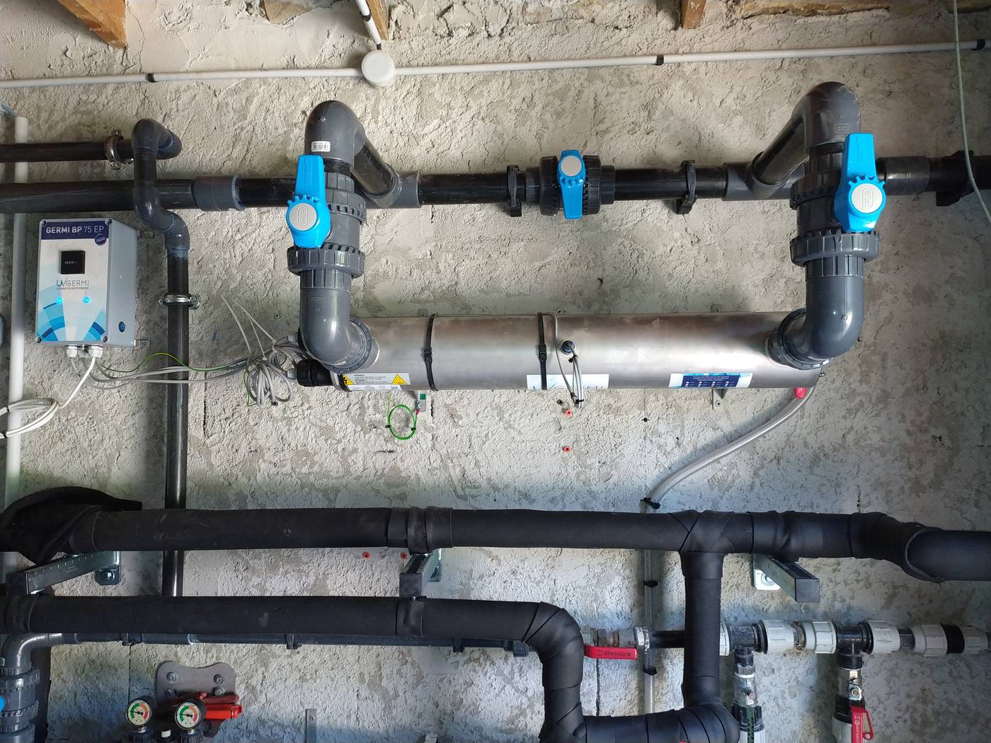 Réseau de canalisations d'eau sous un évier, contrôlé par un plombier d'Atout Travaux
